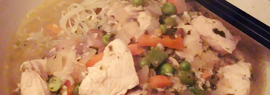 A white bowl of green Thai curry soup with black chopsticks